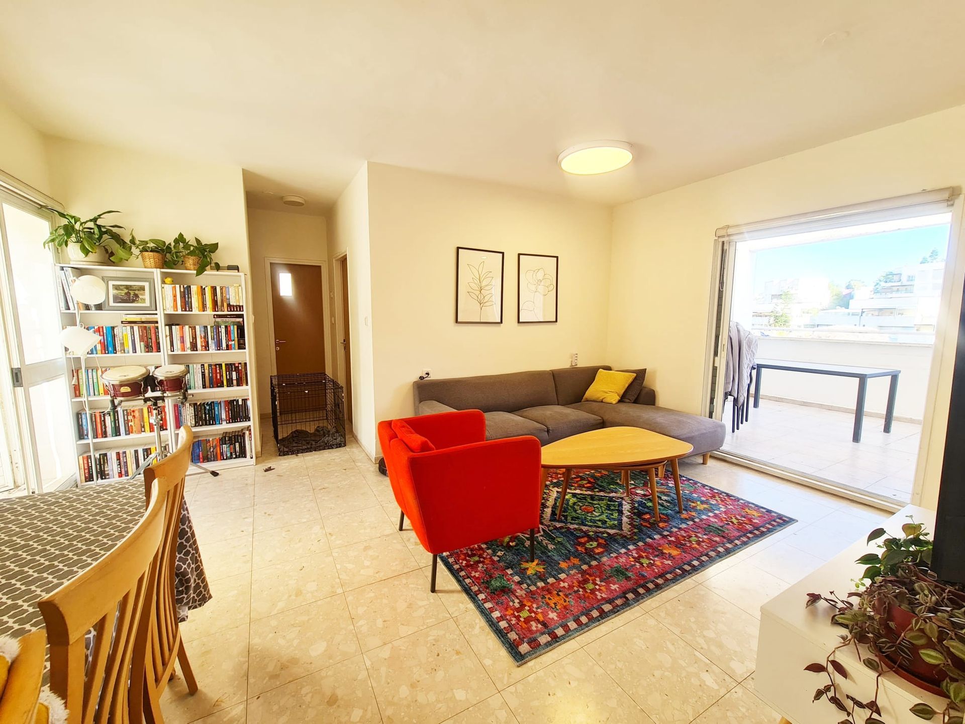 סלון עם ספה, כיסאות, שולחן ומדף ספרים.