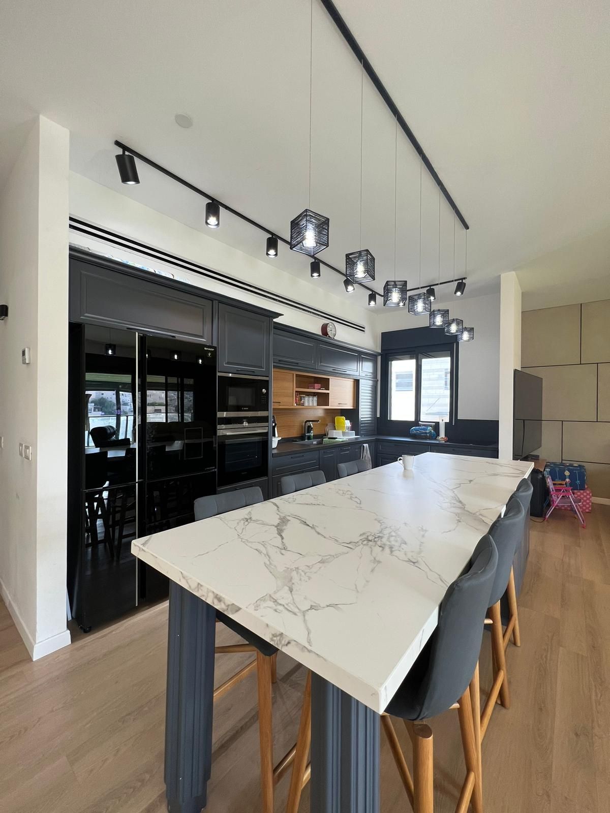 מטבח עם שולחן שיש ארוך וכיסאות