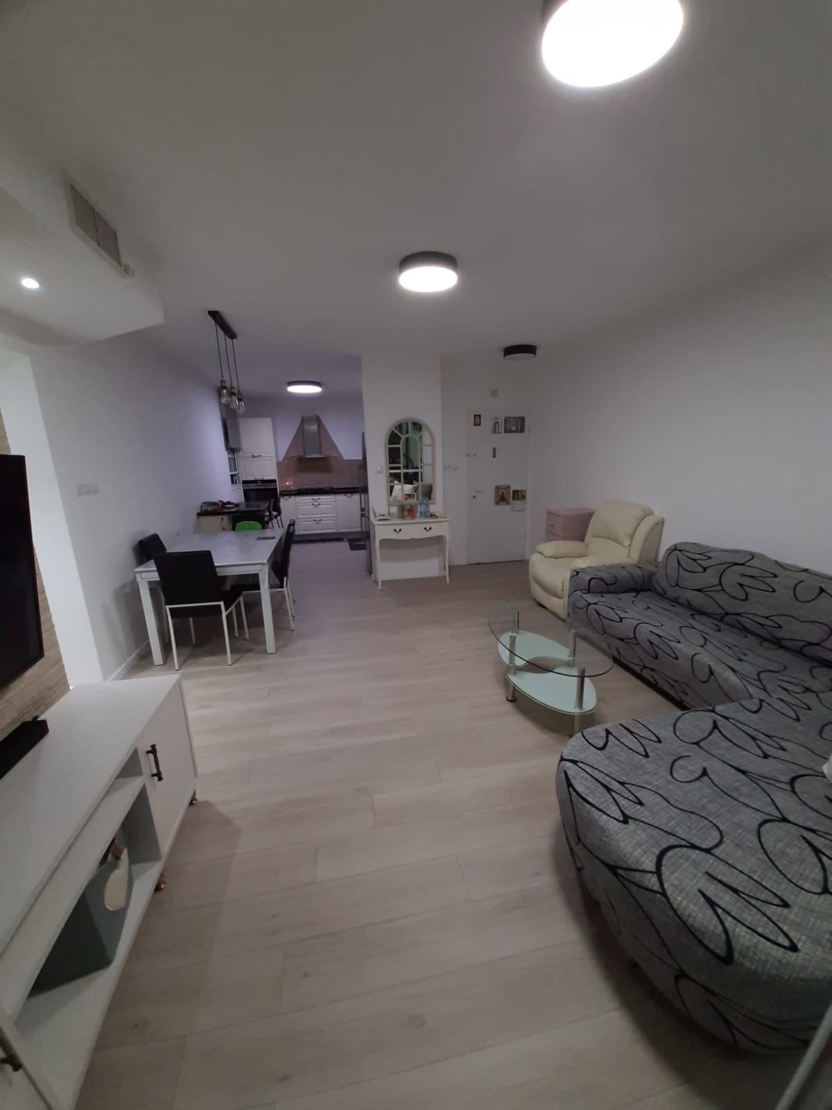 סלון עם ספה, כיסאות, שולחן וטלוויזיה.