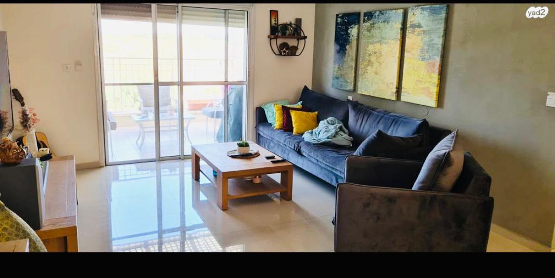 סלון עם ספה כחולה ושולחן קפה.