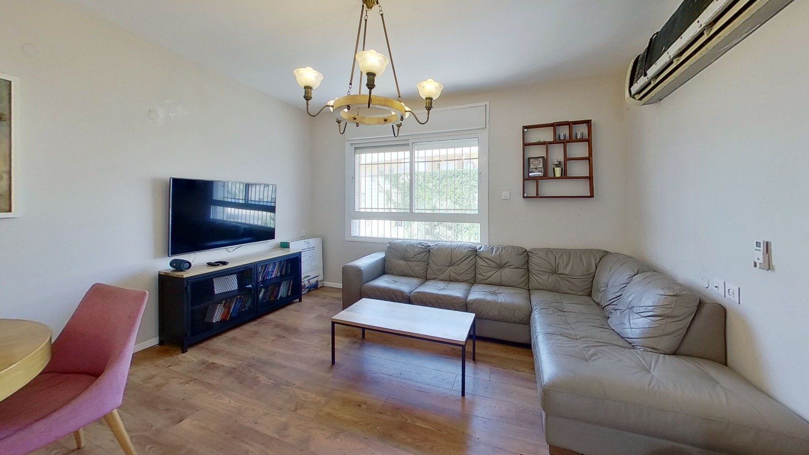 סלון עם ספה, שולחן וטלוויזיה.