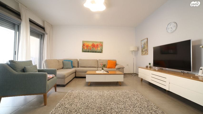 סלון מלא ברהיטים וטלוויזיה בעלת מסך שטוח.