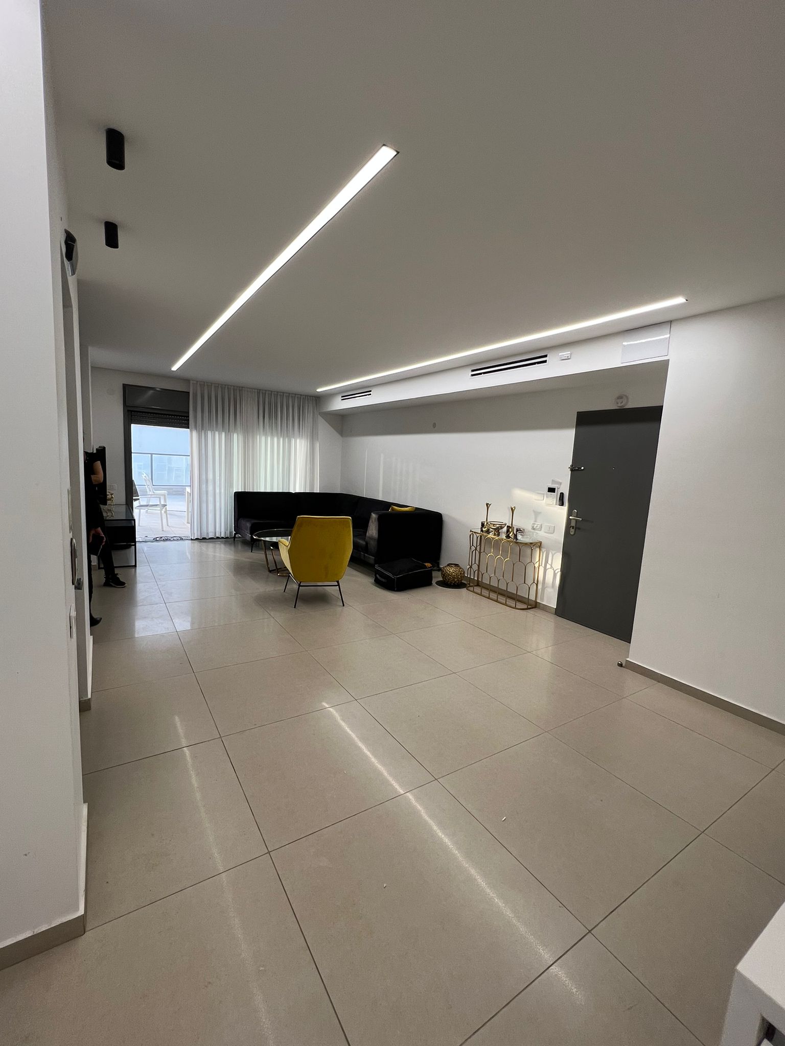 סלון עם קירות לבנים וכיסא צהוב