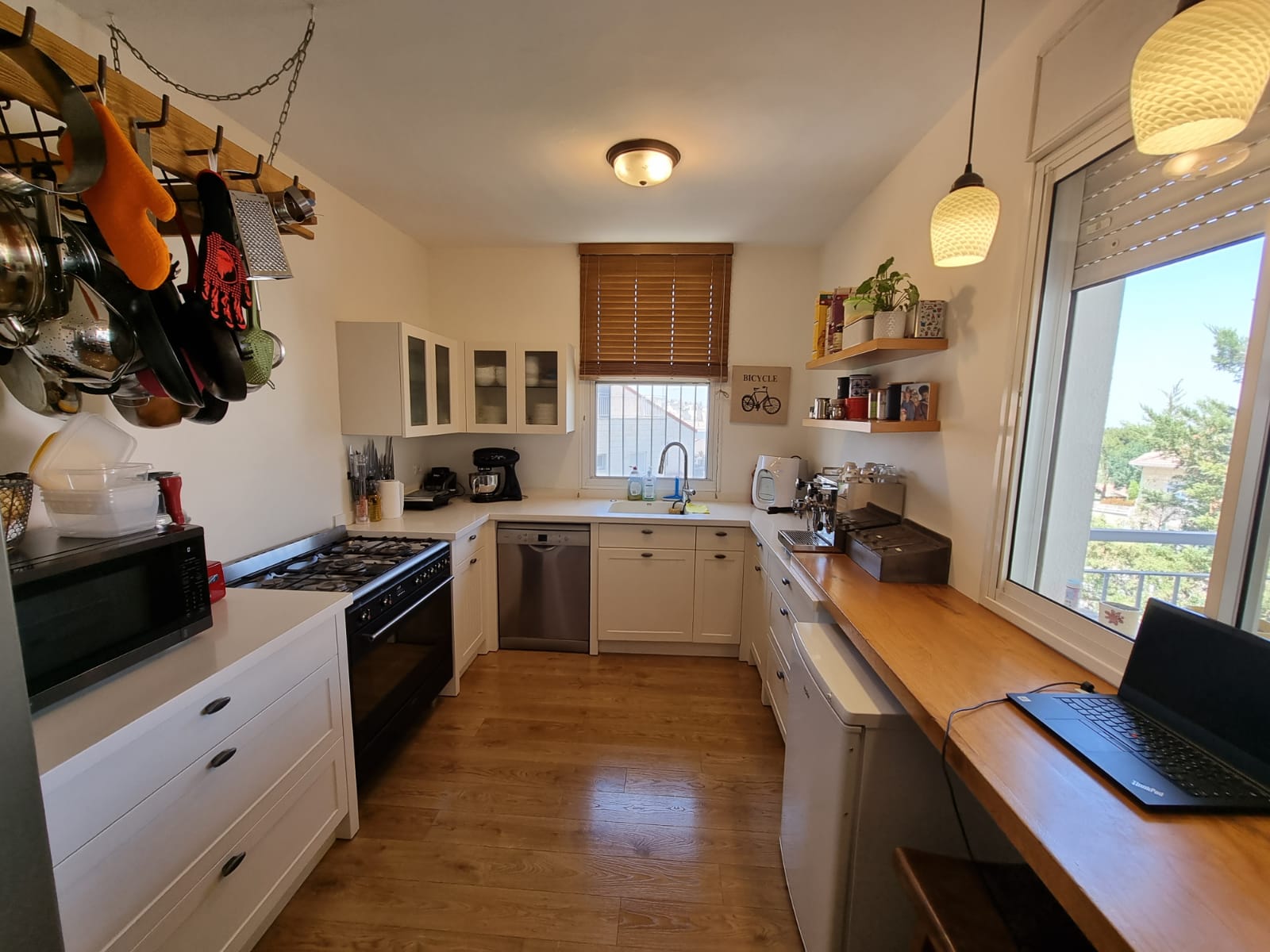 מטבח עם חלון גדול ומחשב נייד על השיש.