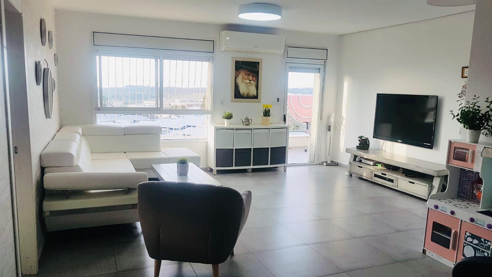 סלון עם ספה, כיסא וטלוויזיה.