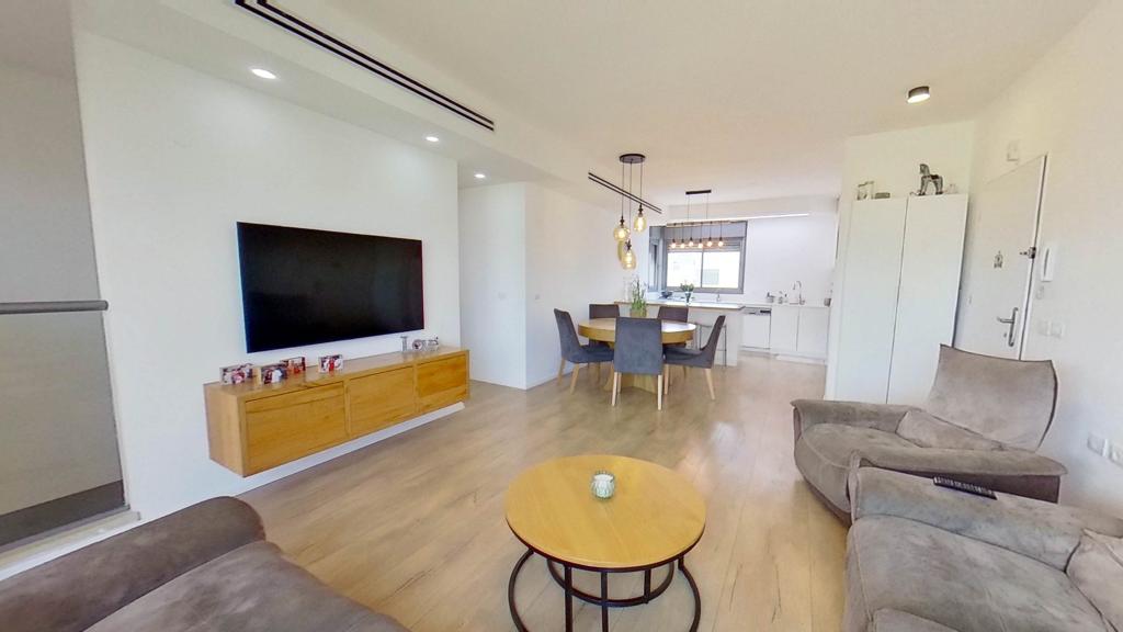 סלון עם ספה, שולחן וטלוויזיה.