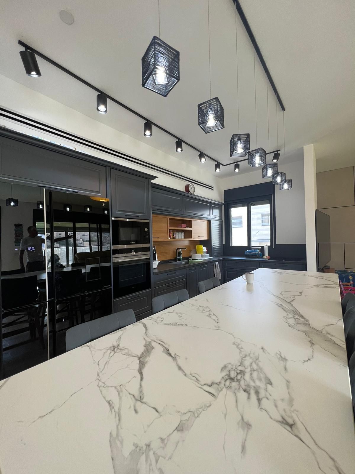 מטבח עם משטח שיש וארונות שחורים