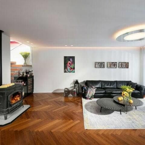 סלון עם ספה שחורה, שני שולחנות קפה ואח.