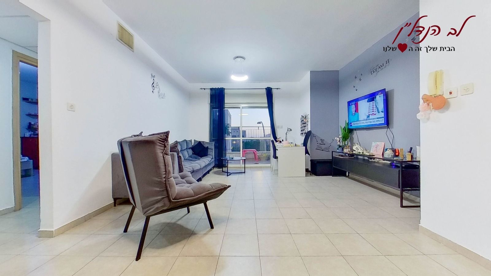 סלון עם ספה, כיסא וטלוויזיה.