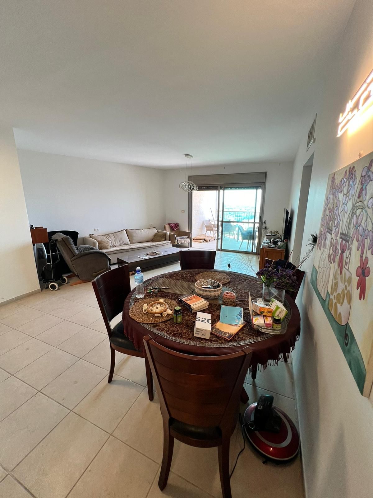 סלון עם שולחן אוכל וכיסאות ושואב אבק.