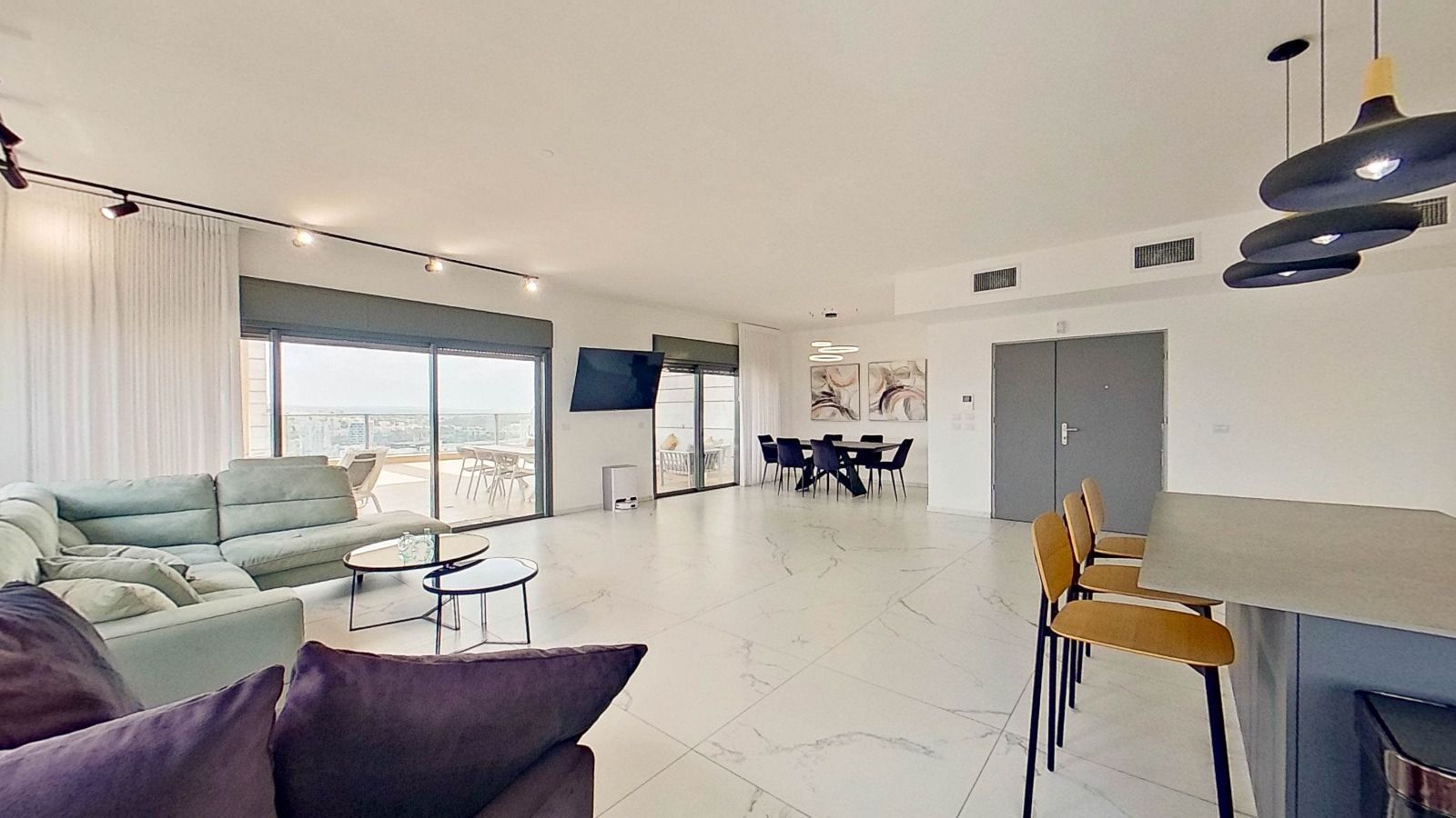 סלון עם ספה, כיסאות, שולחן וטלוויזיה.