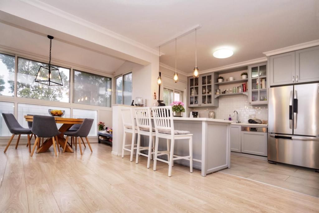 מטבח עם שולחן וכיסאות ומקרר.