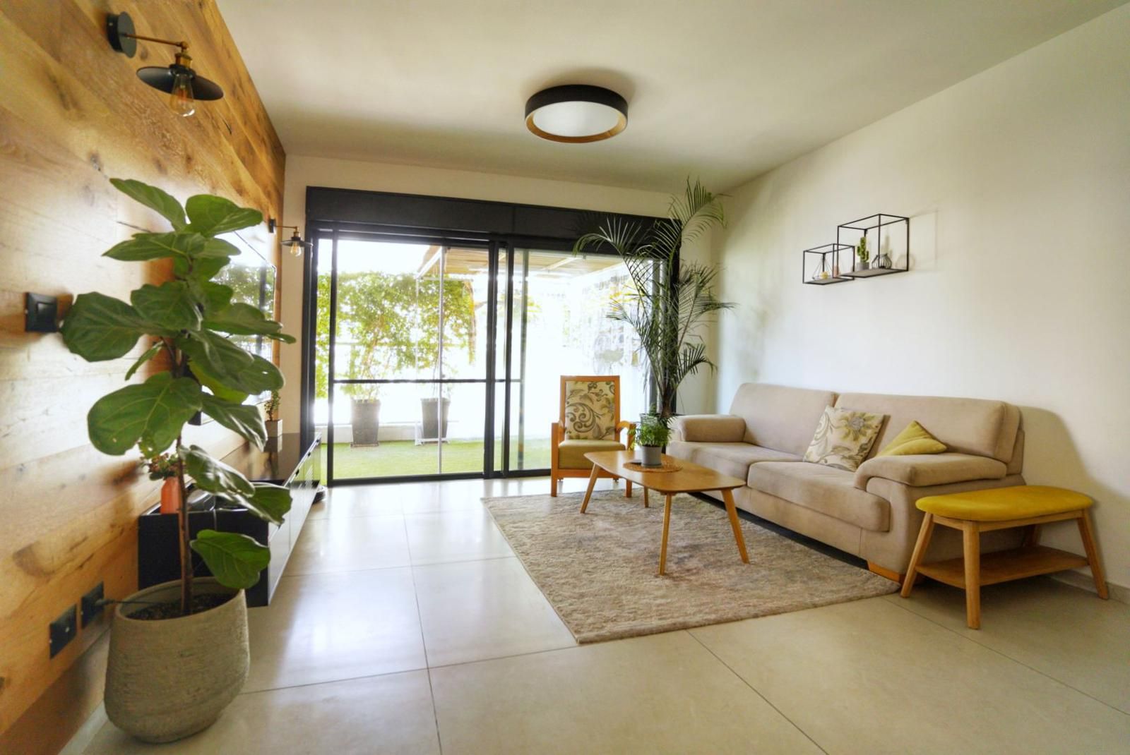 סלון עם ספה, כיסא, שולחן ועציצים.