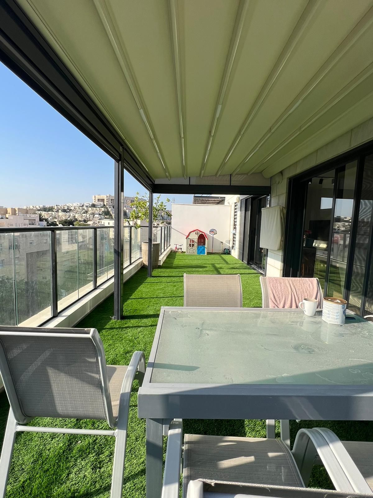 יש שולחן וכיסאות במרפסת.