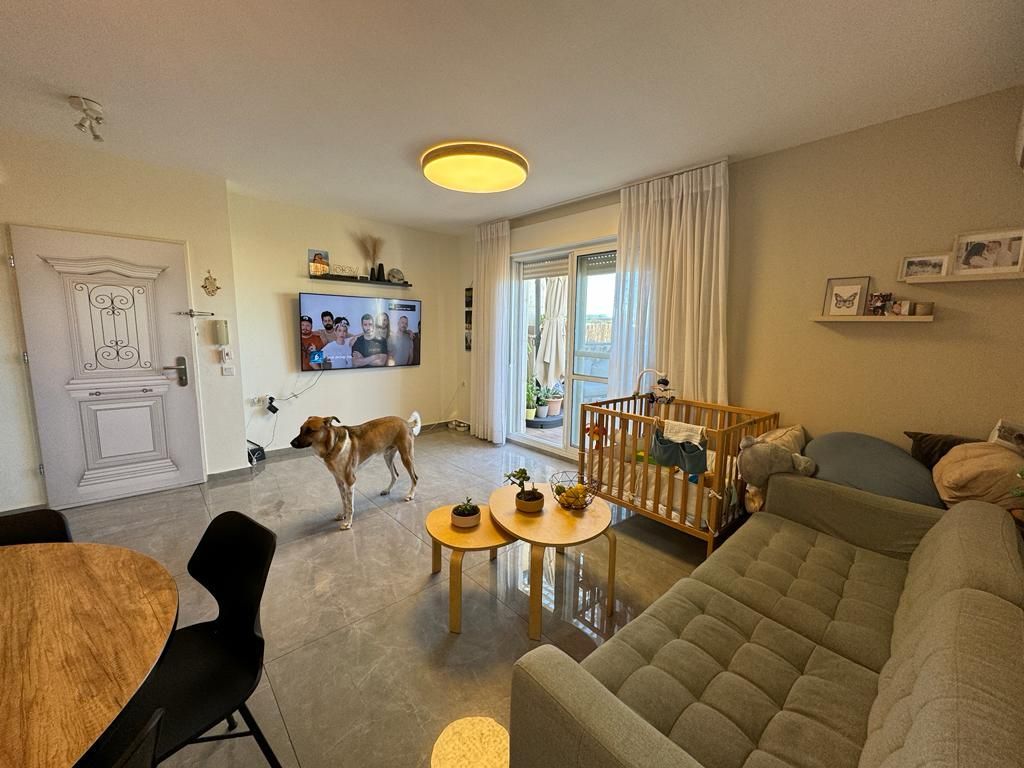 סלון עם ספה, שולחן, כיסאות וכלב.