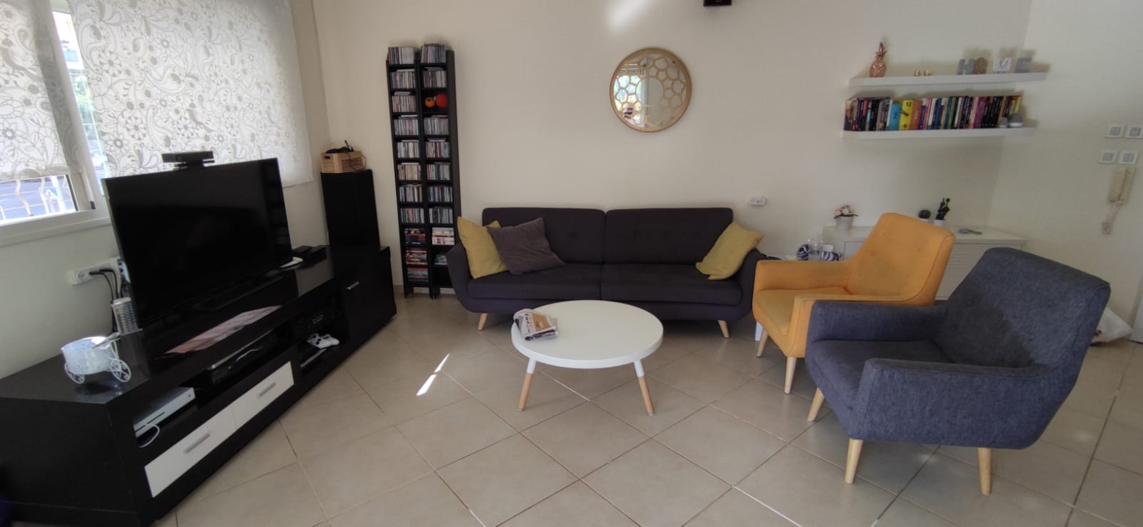 סלון עם ספה, כיסאות וטלוויזיה.