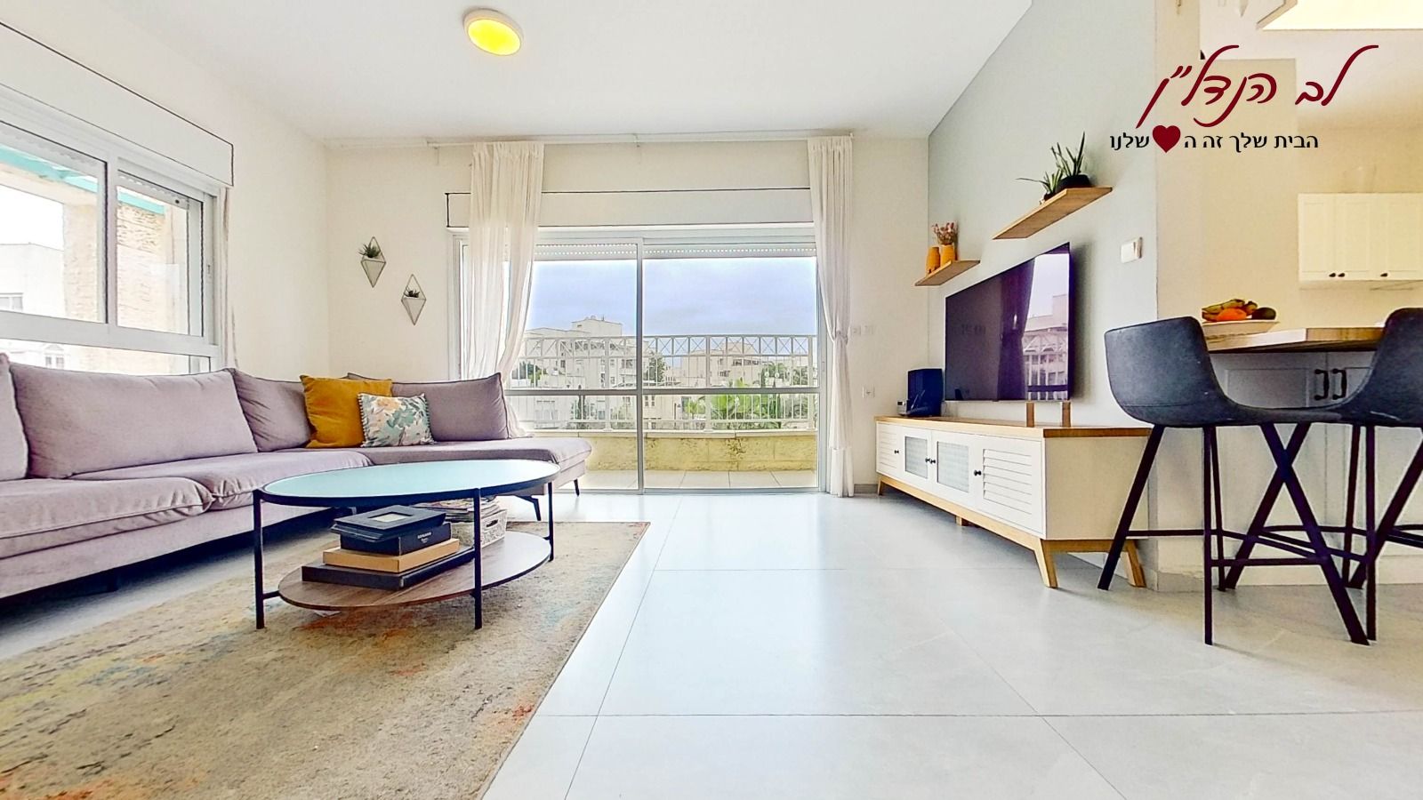 סלון עם ספה, שולחן קפה, טלוויזיה ושרפרפים.