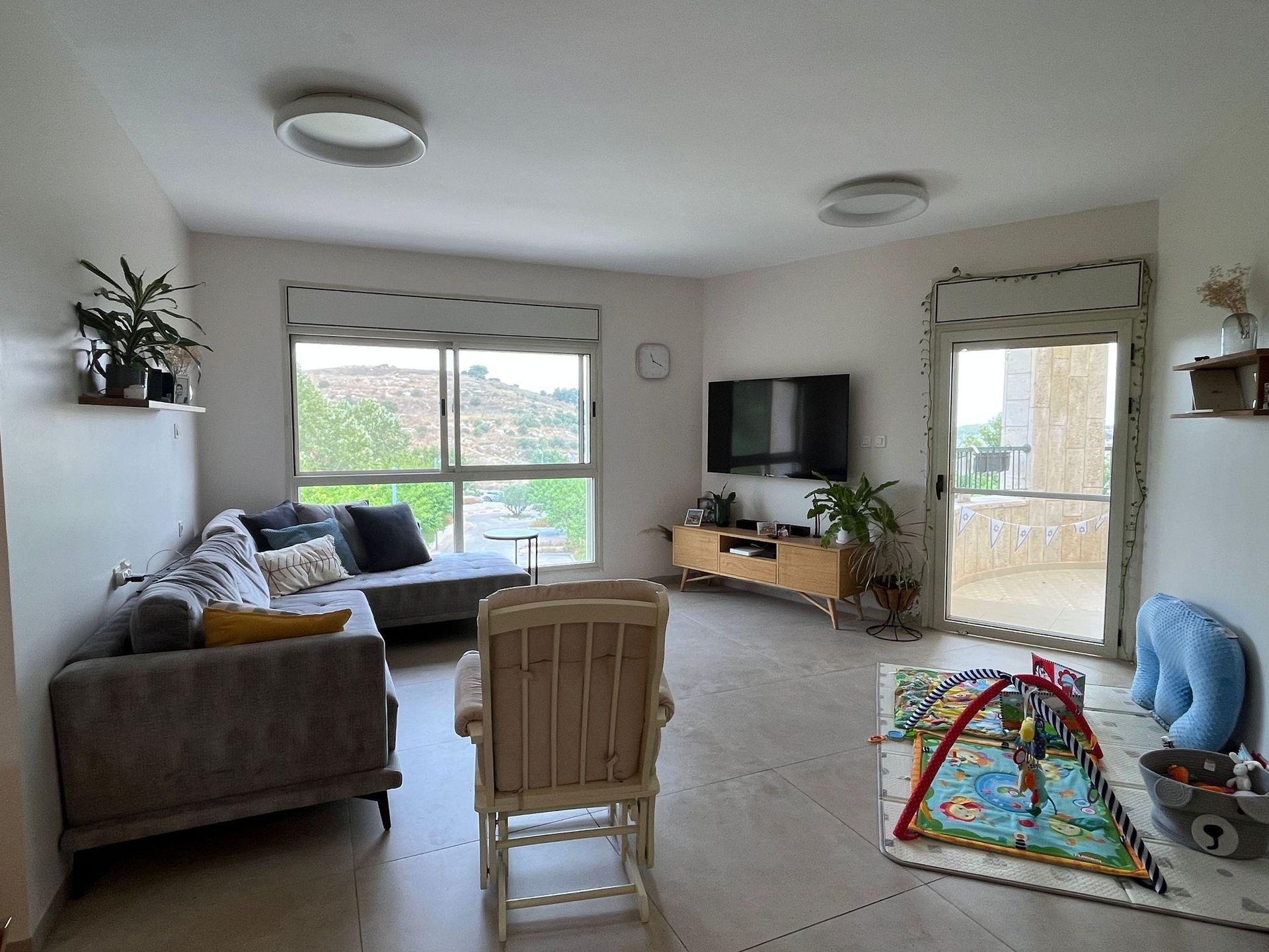 סלון עם ספה, כיסא וטלוויזיה.