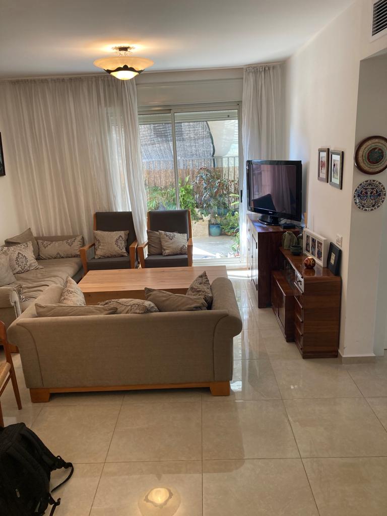 סלון עם ספה, כיסאות וטלוויזיה.