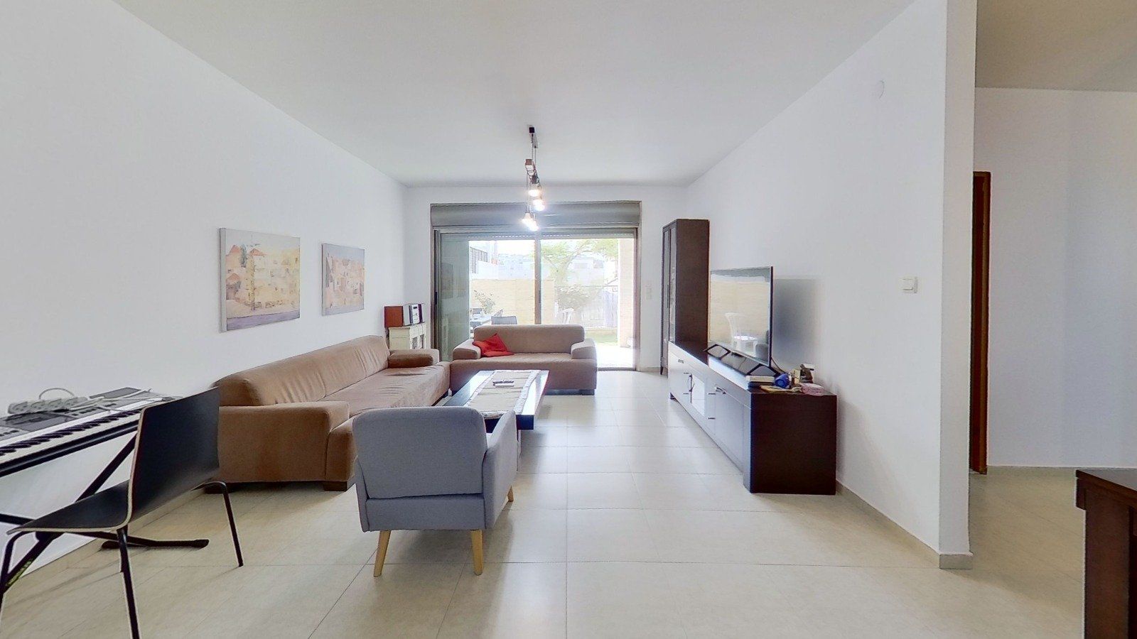 סלון עם ספה, כיסא, שולחן וטלוויזיה.