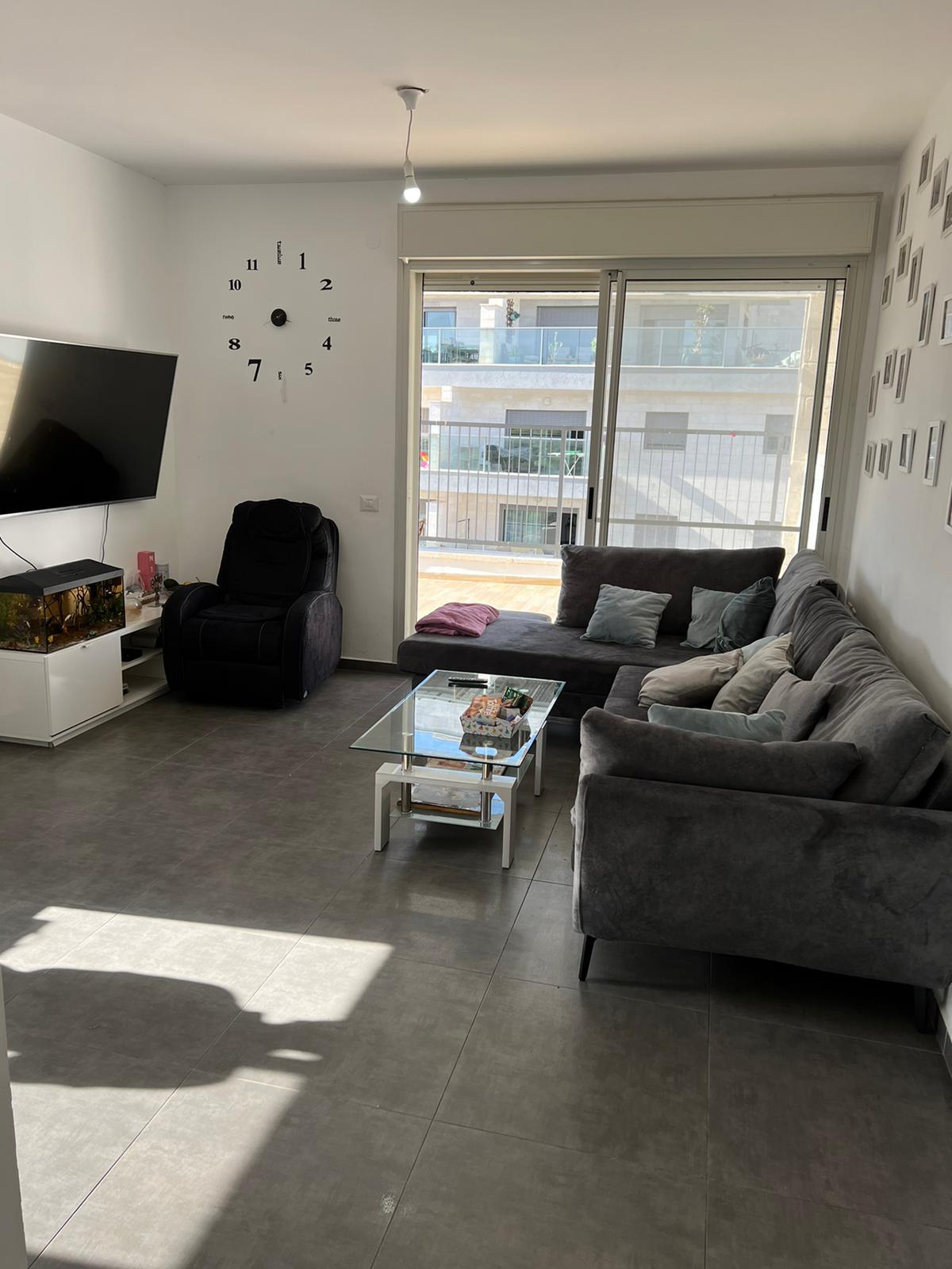 סלון מלא ברהיטים ושעון על הקיר.