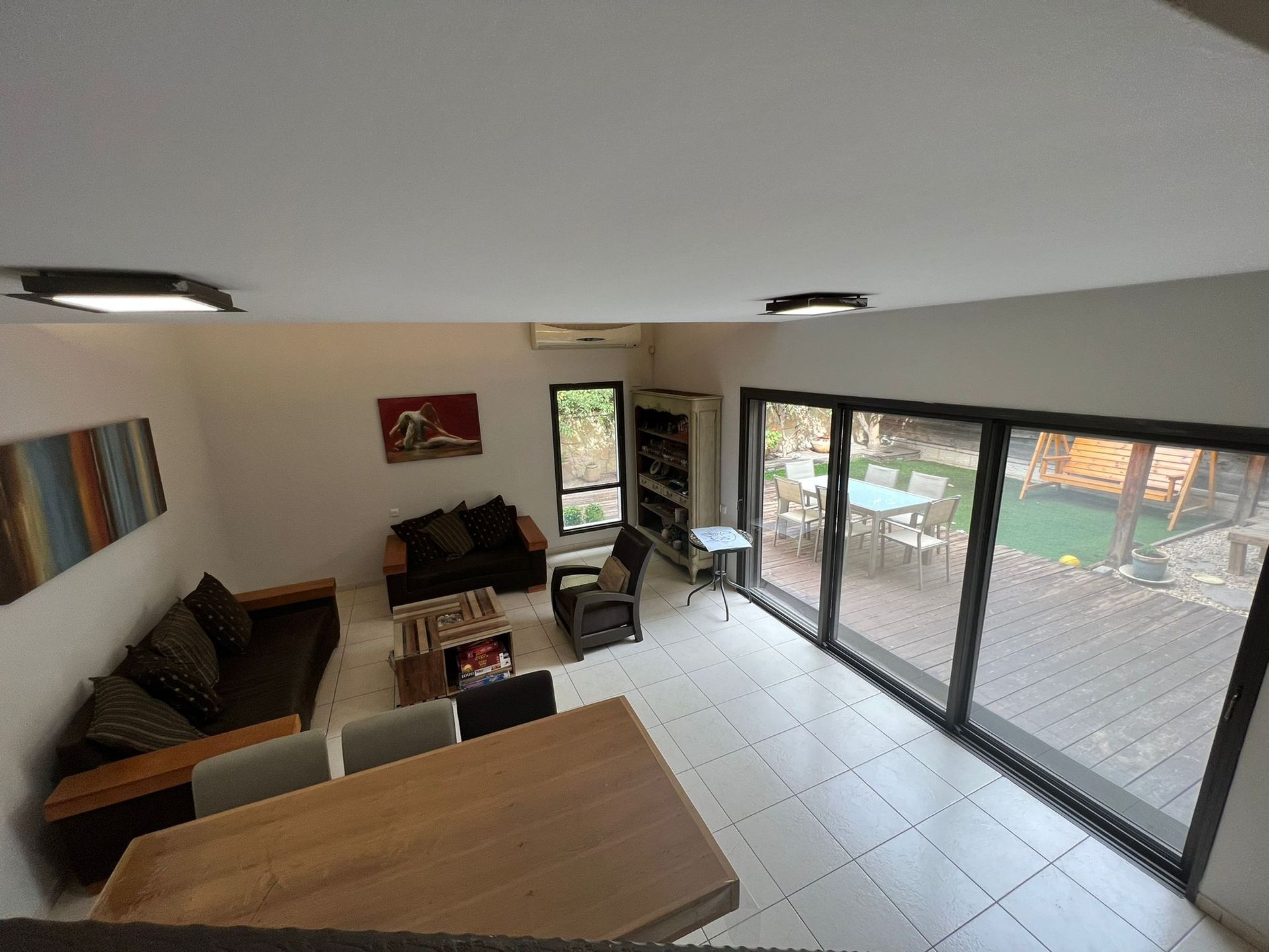 מבט אווירי של סלון עם ספה, שולחן וכיסאות.