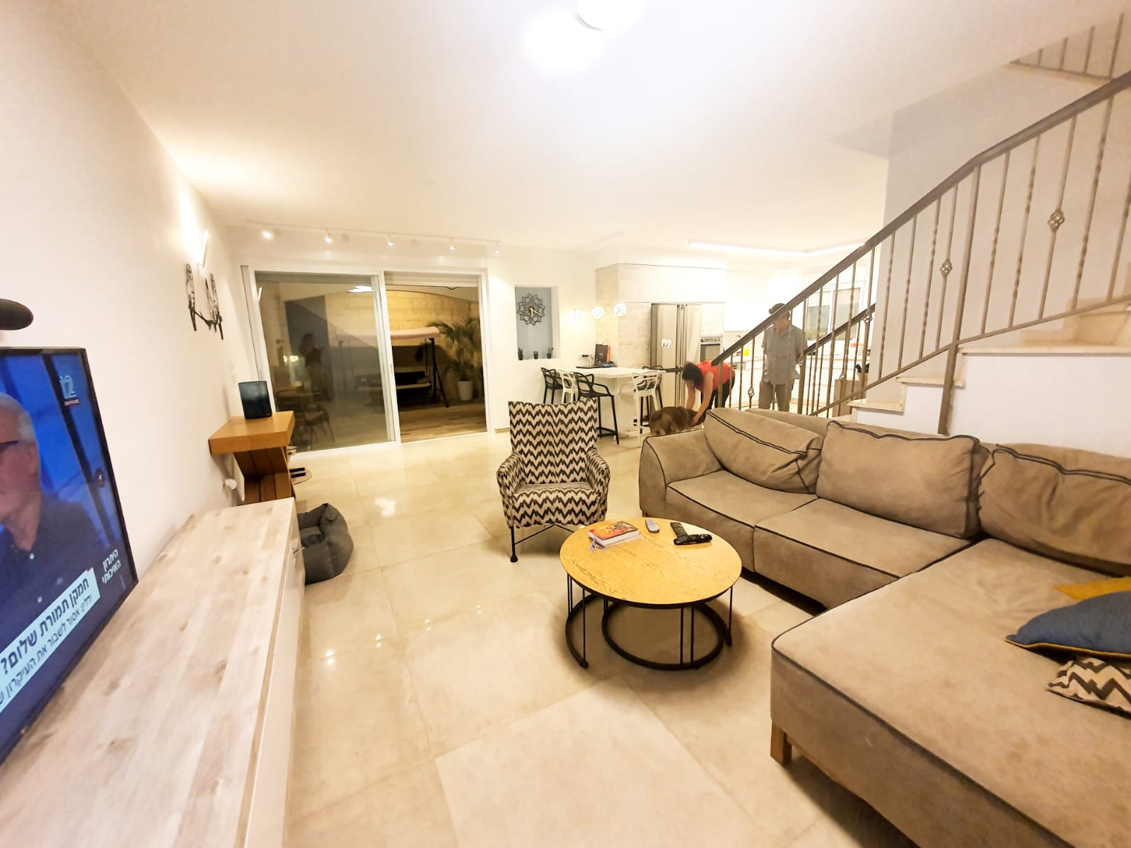 סלון עם ספה, כיסאות, שולחן וטלוויזיה.