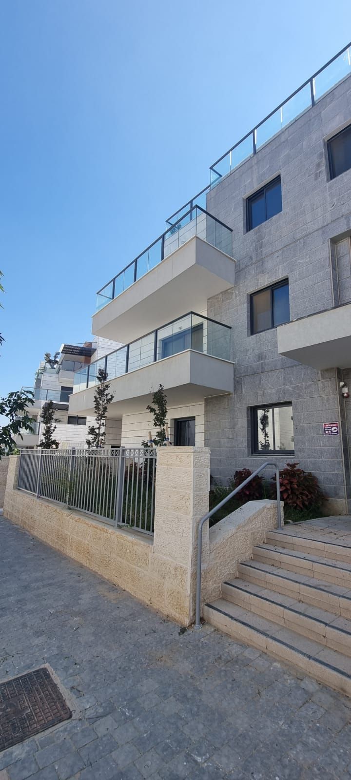 בניין דירות גדול עם מדרגות המובילות אליו.