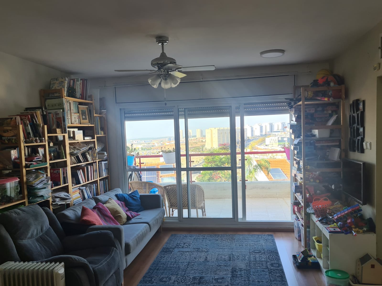 סלון מלא ברהיטים ומאוורר תקרה.