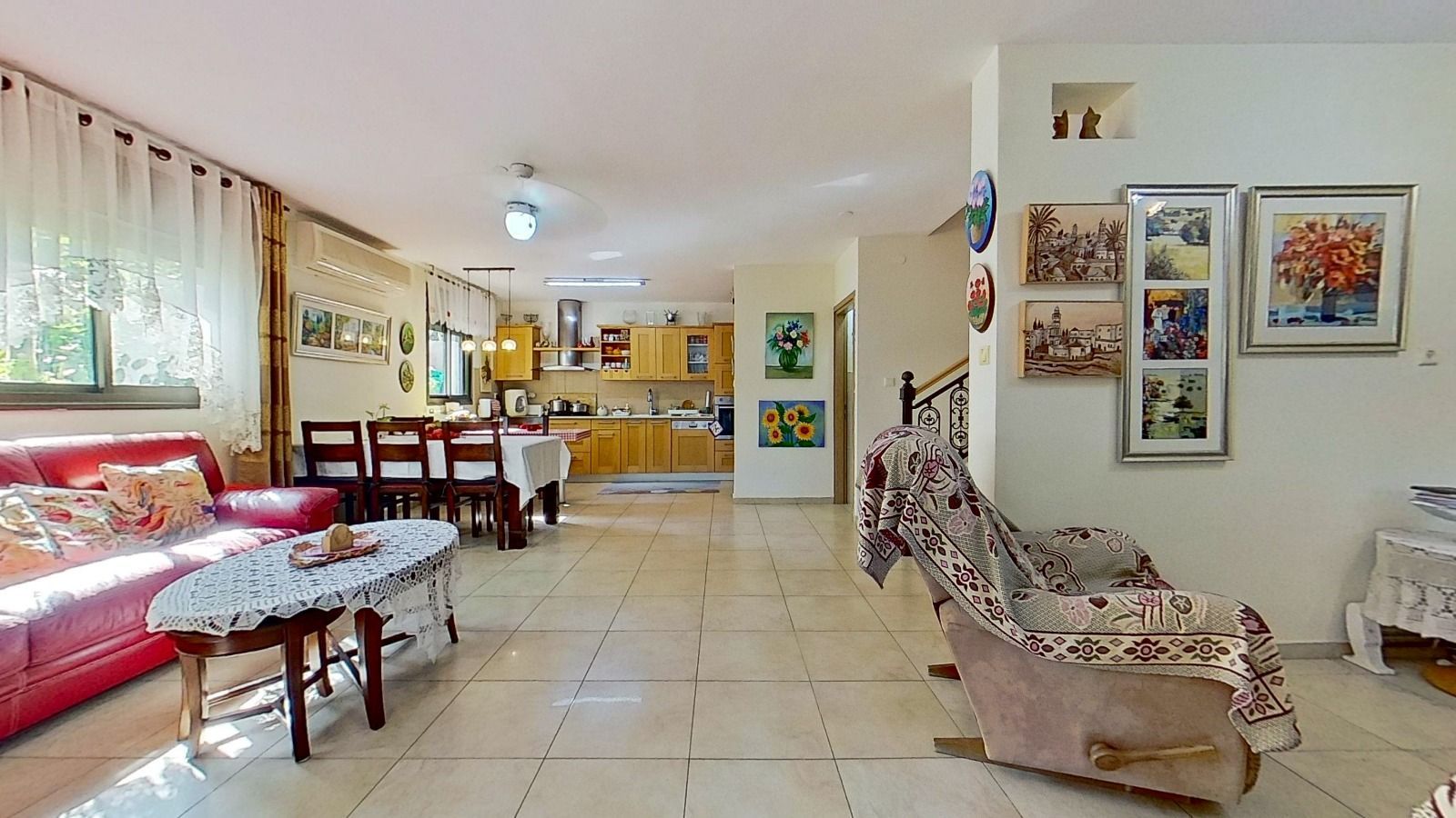 סלון עם ספה אדומה וכיסא נדנדה