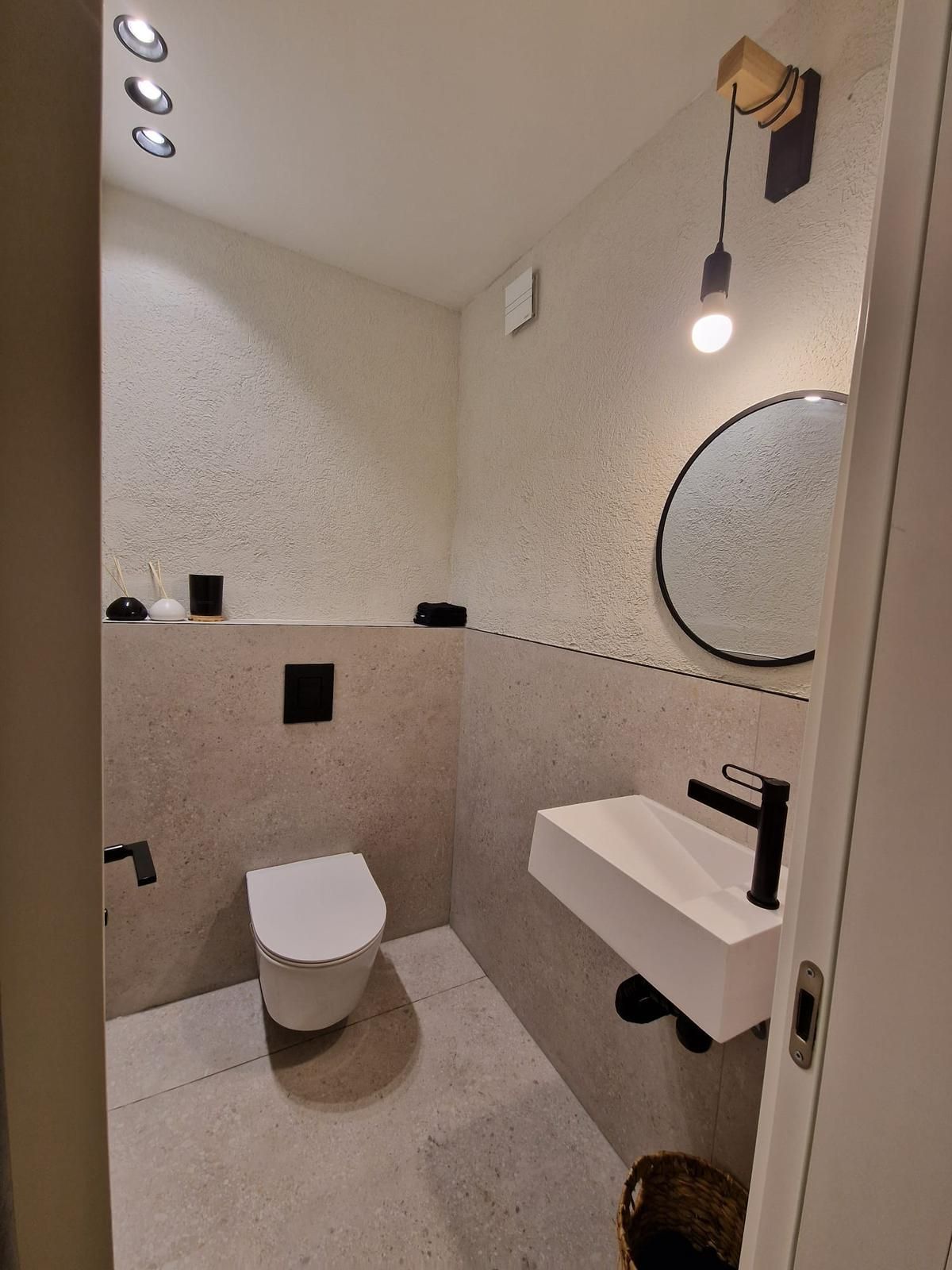 חדר רחצה עם שירותים, כיור ומראה.