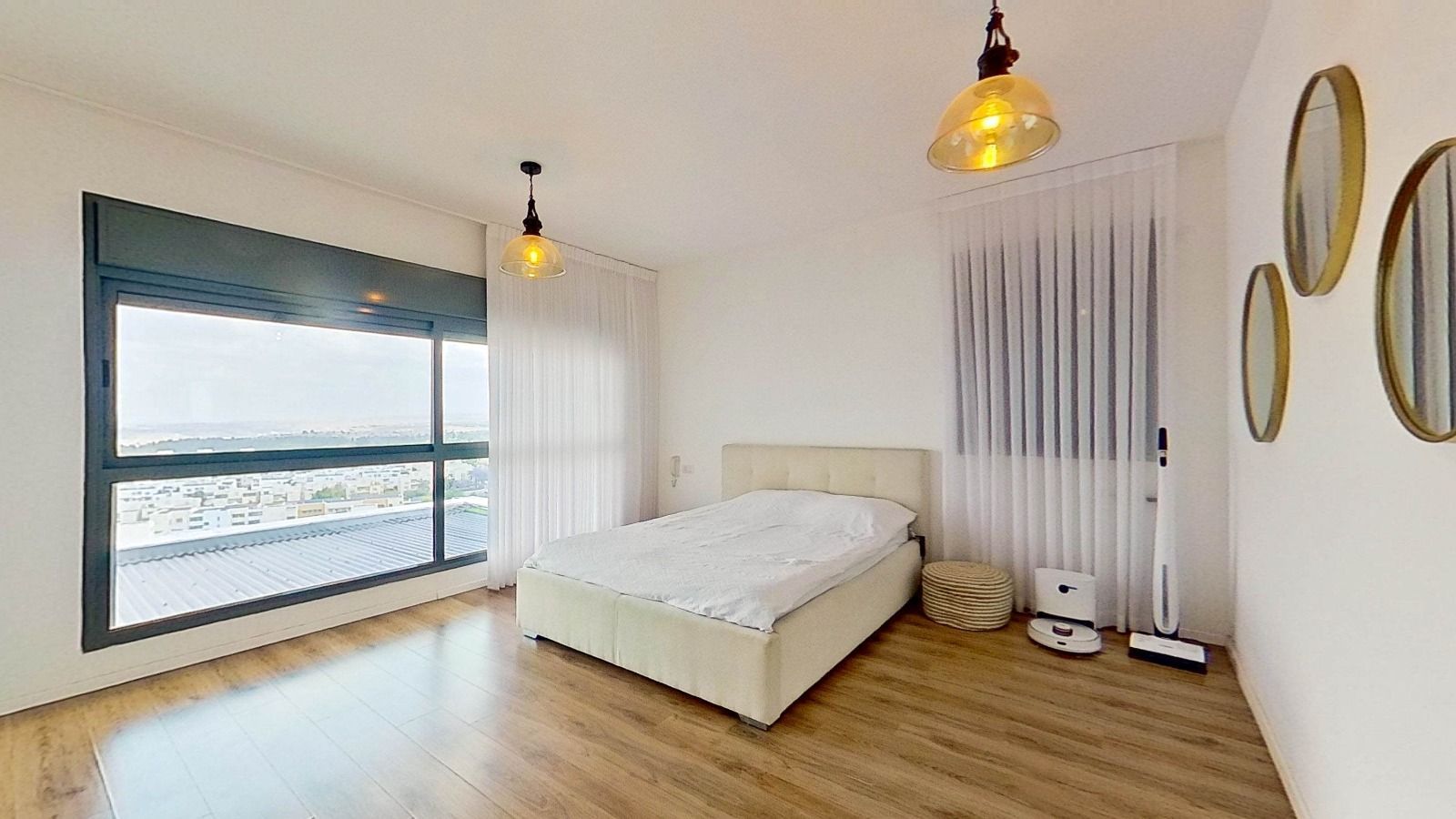 חדר שינה עם מיטה, מראות ושואב אבק.