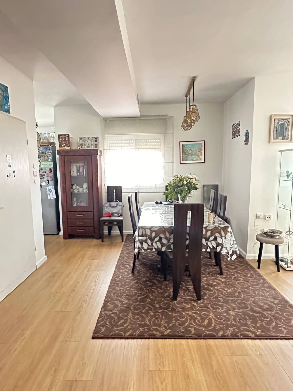 חדר אוכל עם שולחן וכיסאות ושטיח.