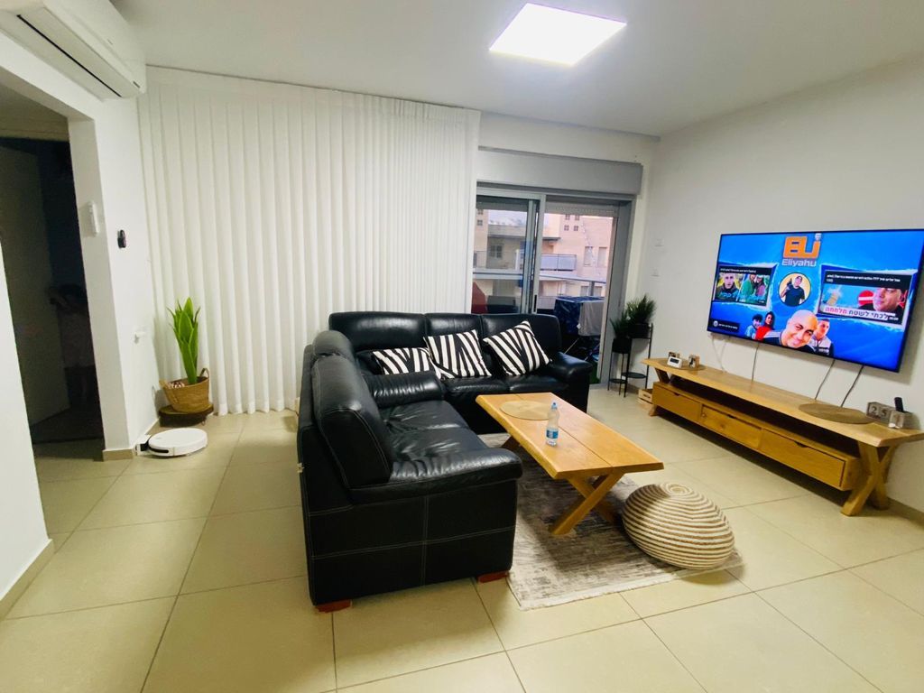 סלון עם ספה, שולחן וטלוויזיה.