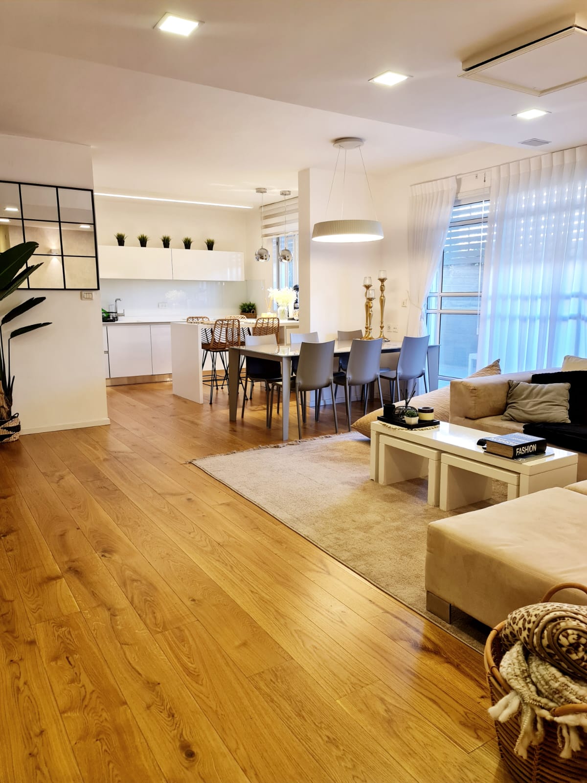 סלון עם רצפות עץ, ספה, שולחן וכיסאות.