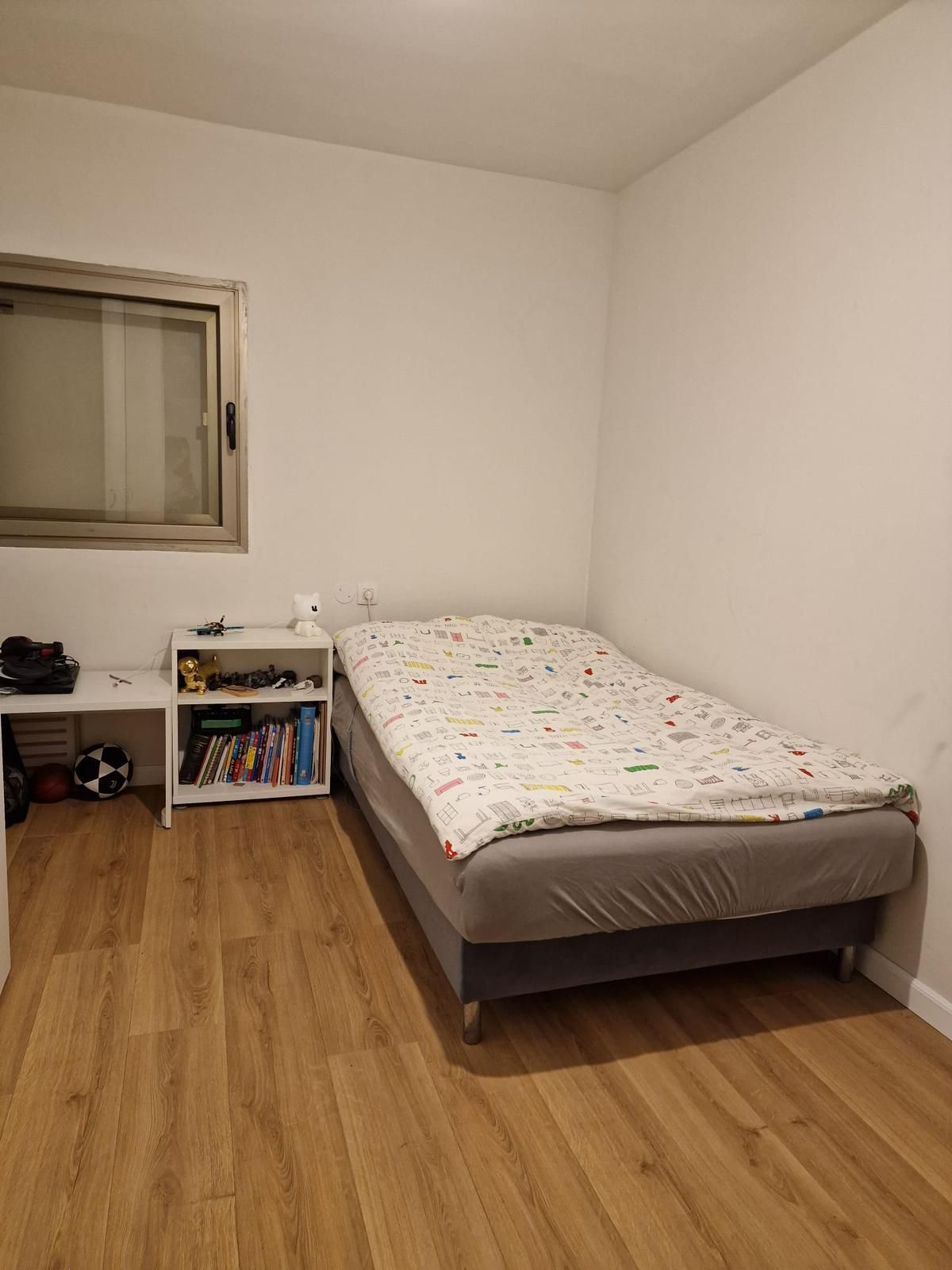 חדר שינה עם מיטת יחיד וחלון.