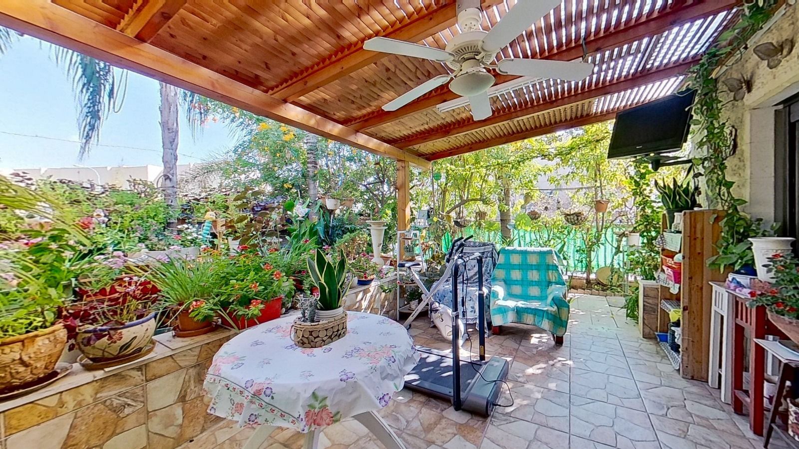 פטיו עם שולחן, כיסאות ומאוורר תקרה.