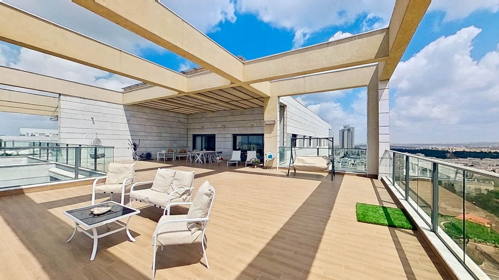 מרפסת עם נוף לעיר ועליה שולחן וכיסאות.
