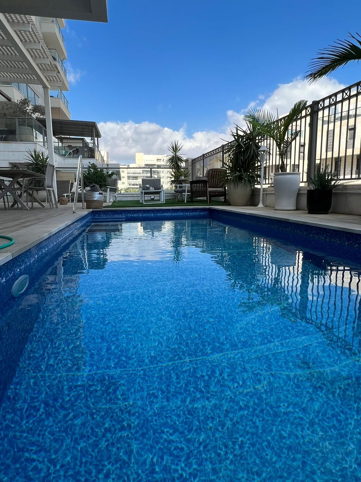 בריכת שחייה גדולה מוקפת בגדר ובבניין.