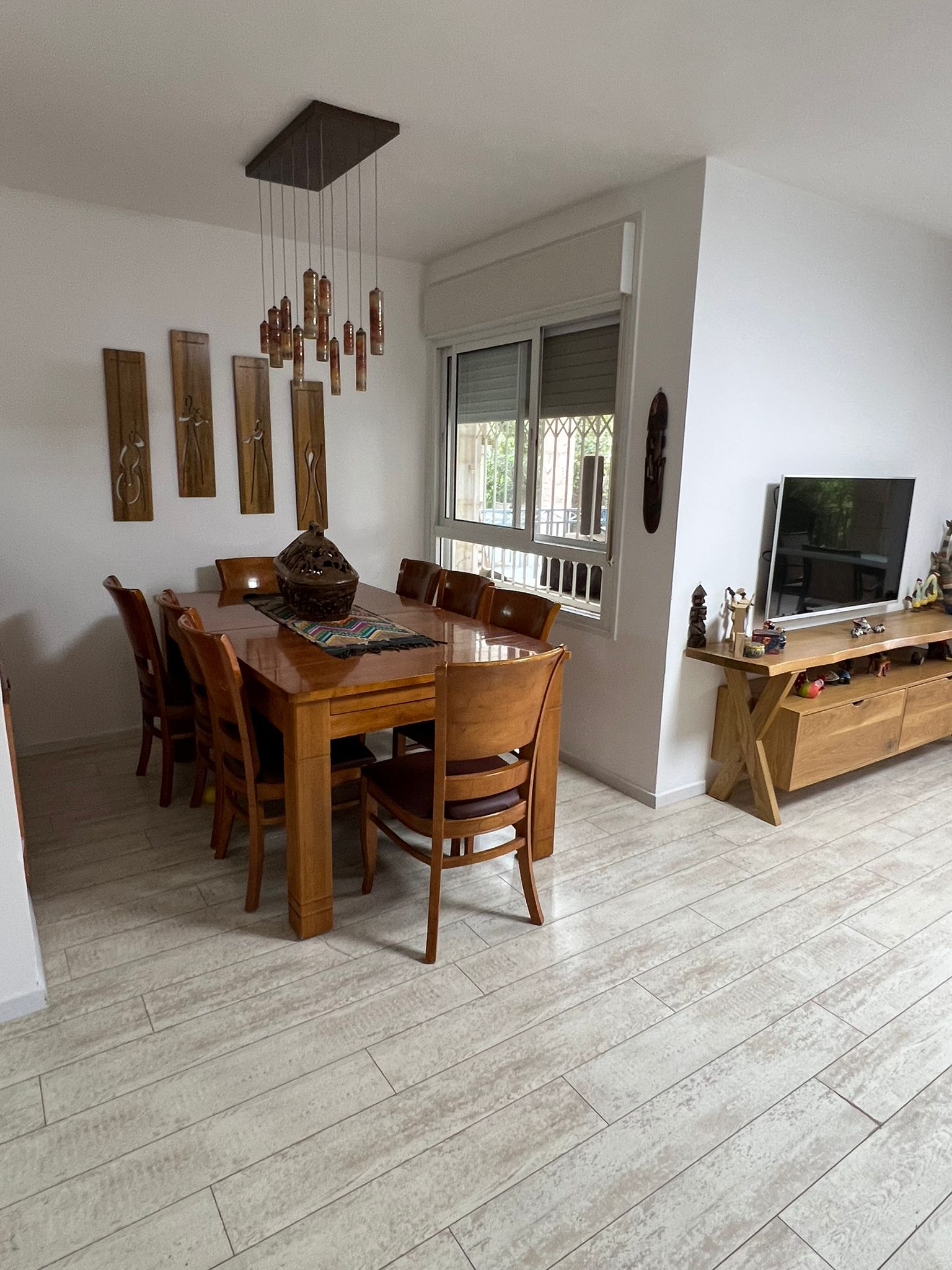 חדר אוכל עם שולחן וכיסאות וטלוויזיה.