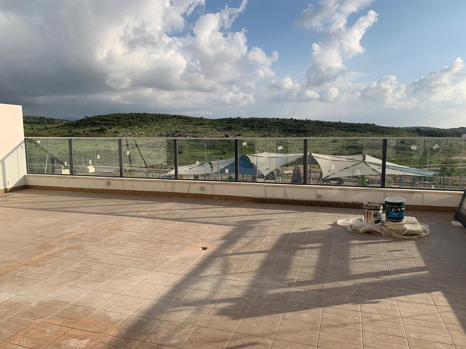 מרפסת גג עם נוף של עיר והרים.