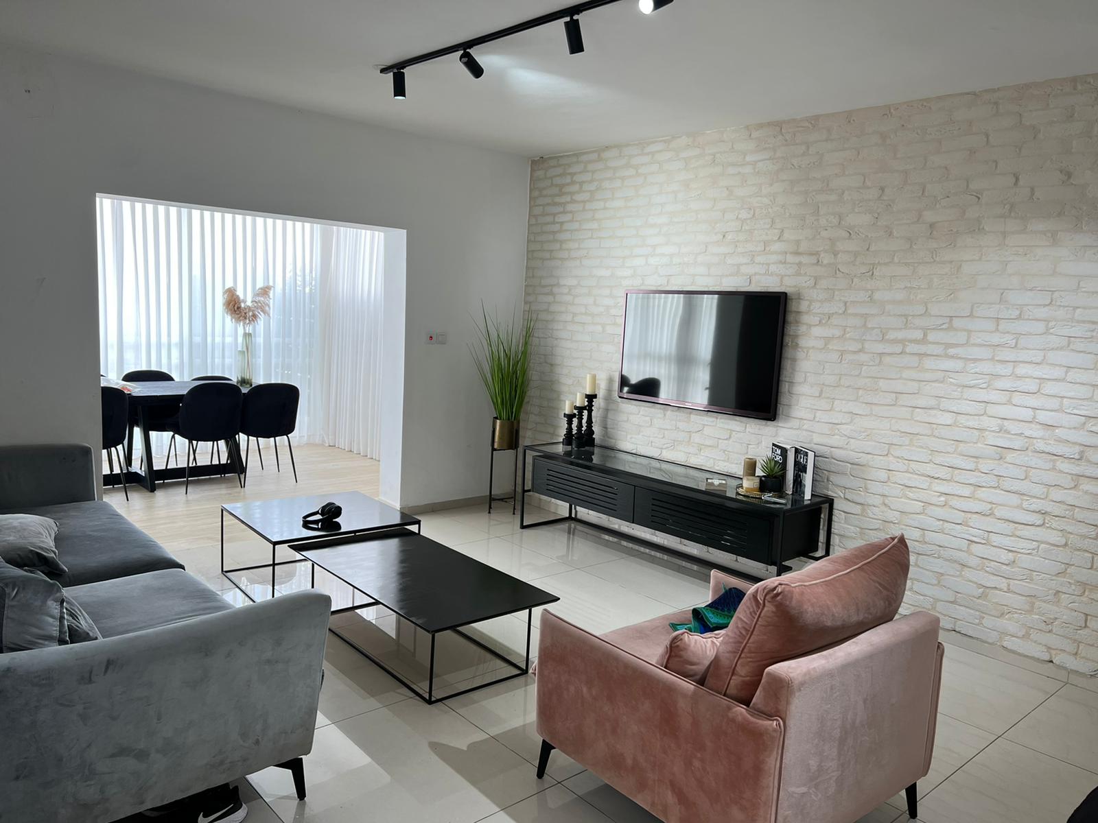 סלון עם ספה, כיסא, שולחן קפה וטלוויזיה.