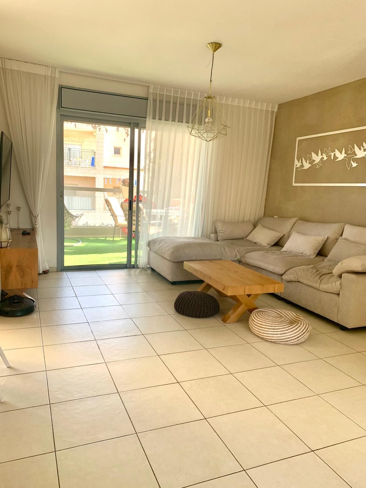 סלון עם ספה, שולחן קפה וטלוויזיה.