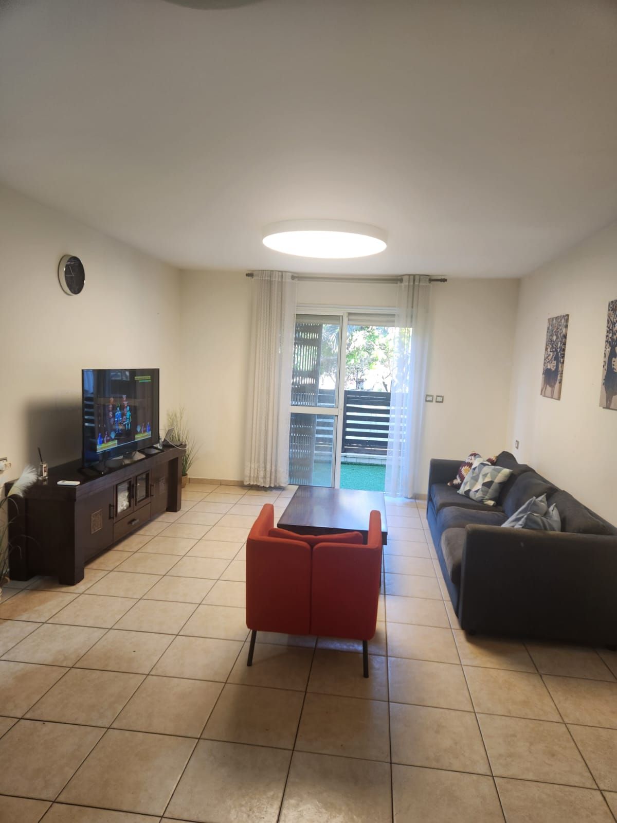 סלון עם ספה, כיסא, שולחן קפה וטלוויזיה.