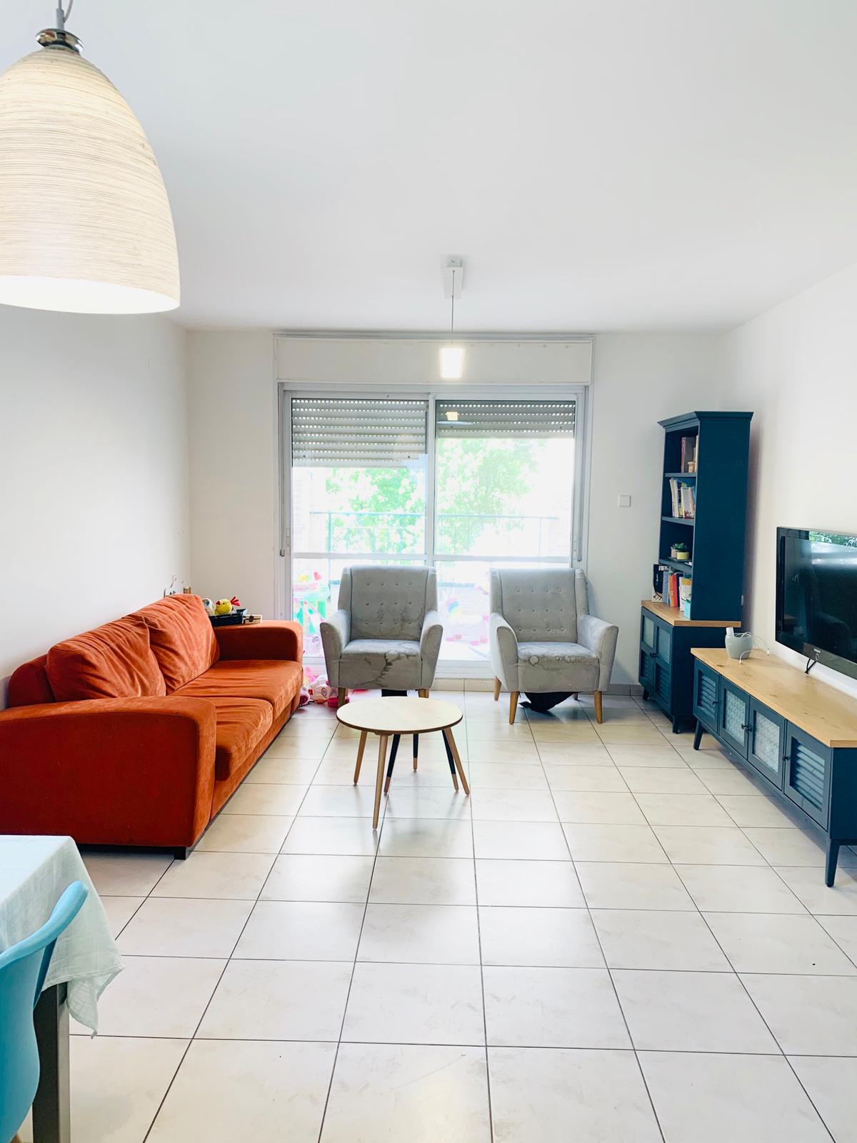 סלון עם ספה, כיסאות, שולחן וטלוויזיה.