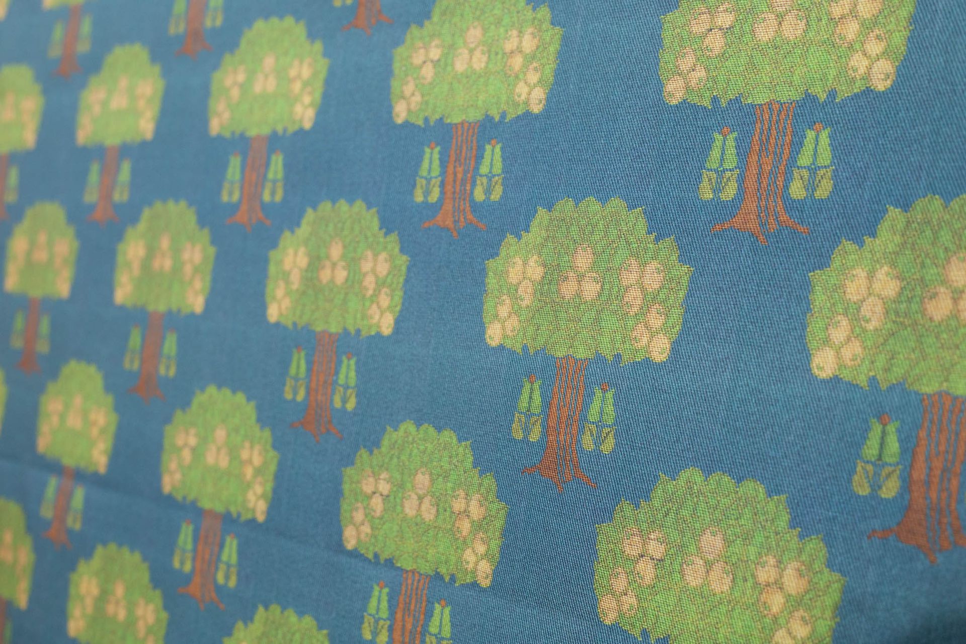 A close up of a piece of fabric with a pattern of trees on it.