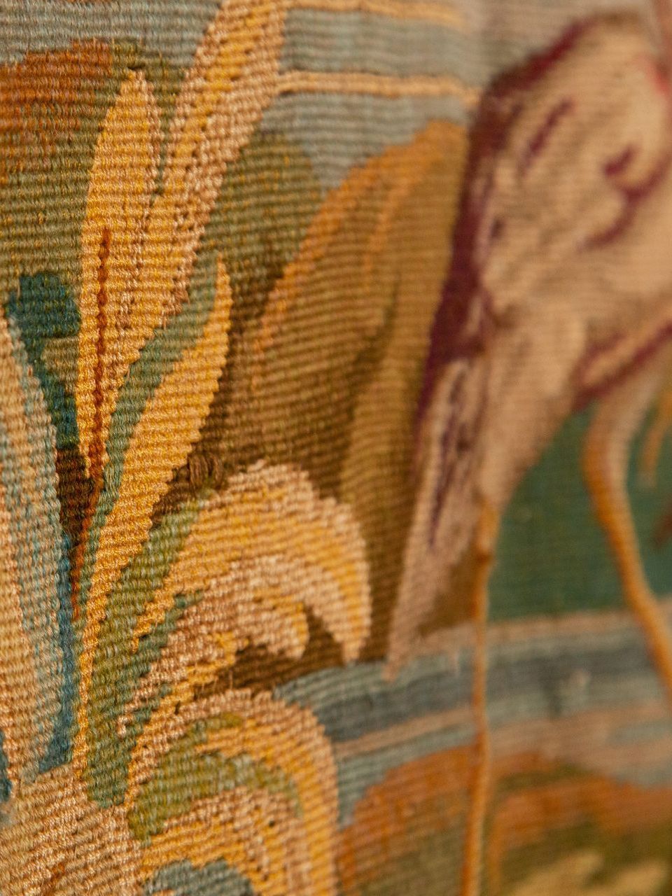 A close up of a tapestry of a bird on a wall.