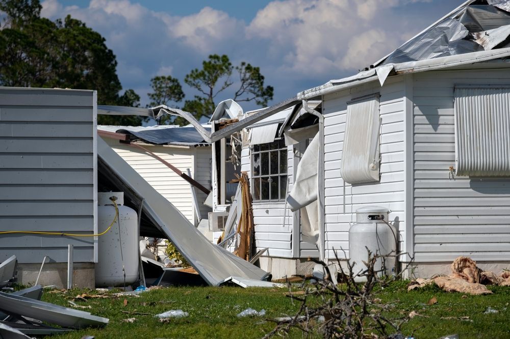 a white house with a roof that has been damaged by a tornado