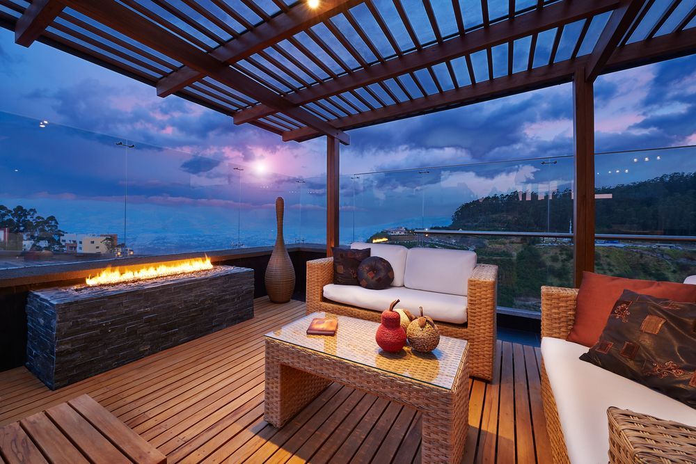 a patio with a fire pit and a view of the ocean