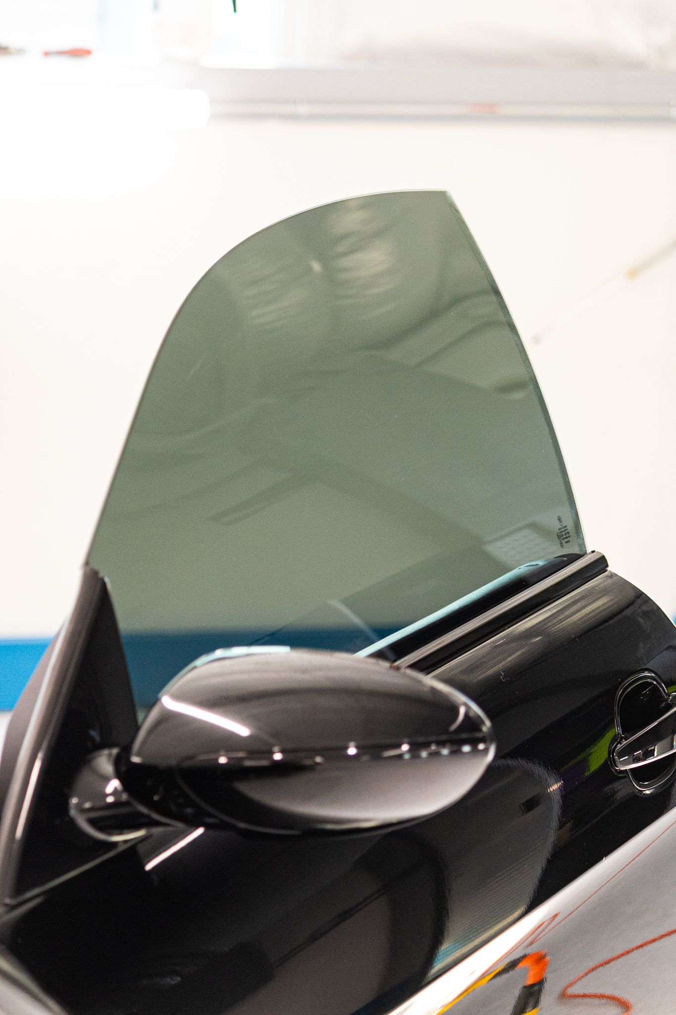 A man is applying tinted glass to a car window.